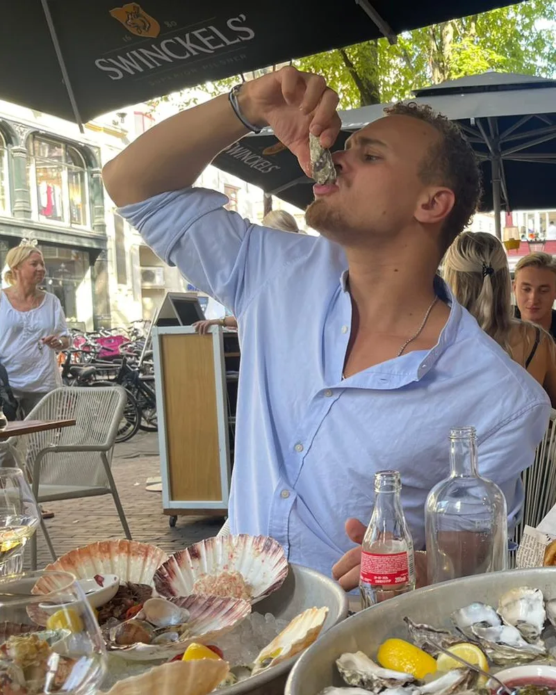 Nelson Archer eet een oester op een terras